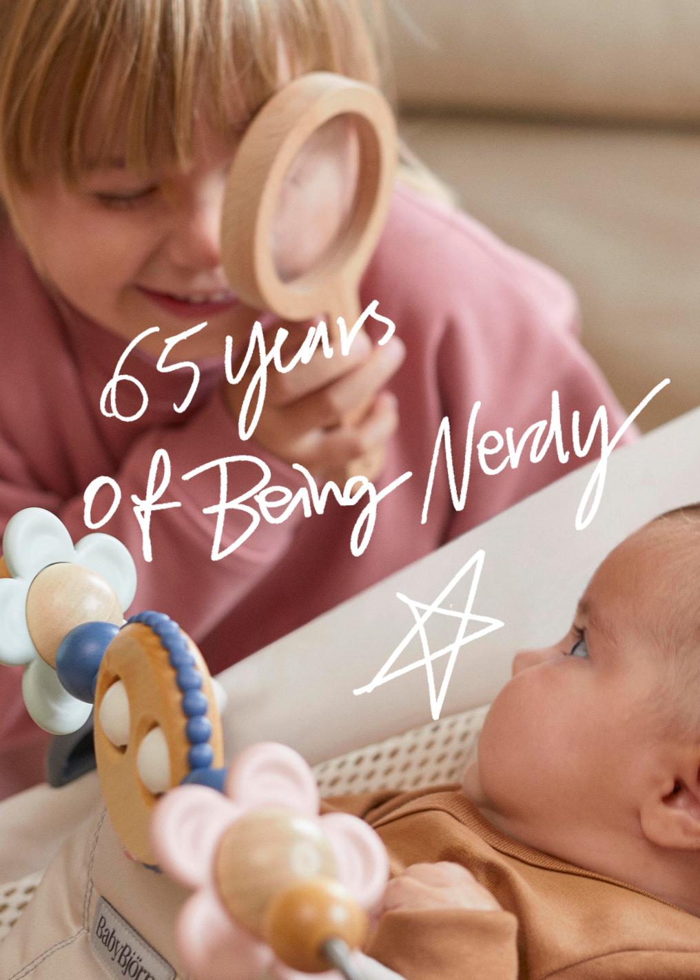 Child smiling through a wooden magnifying glass at a baby in a crib; text reads "65 years of being Nevaly" with a doodled star.